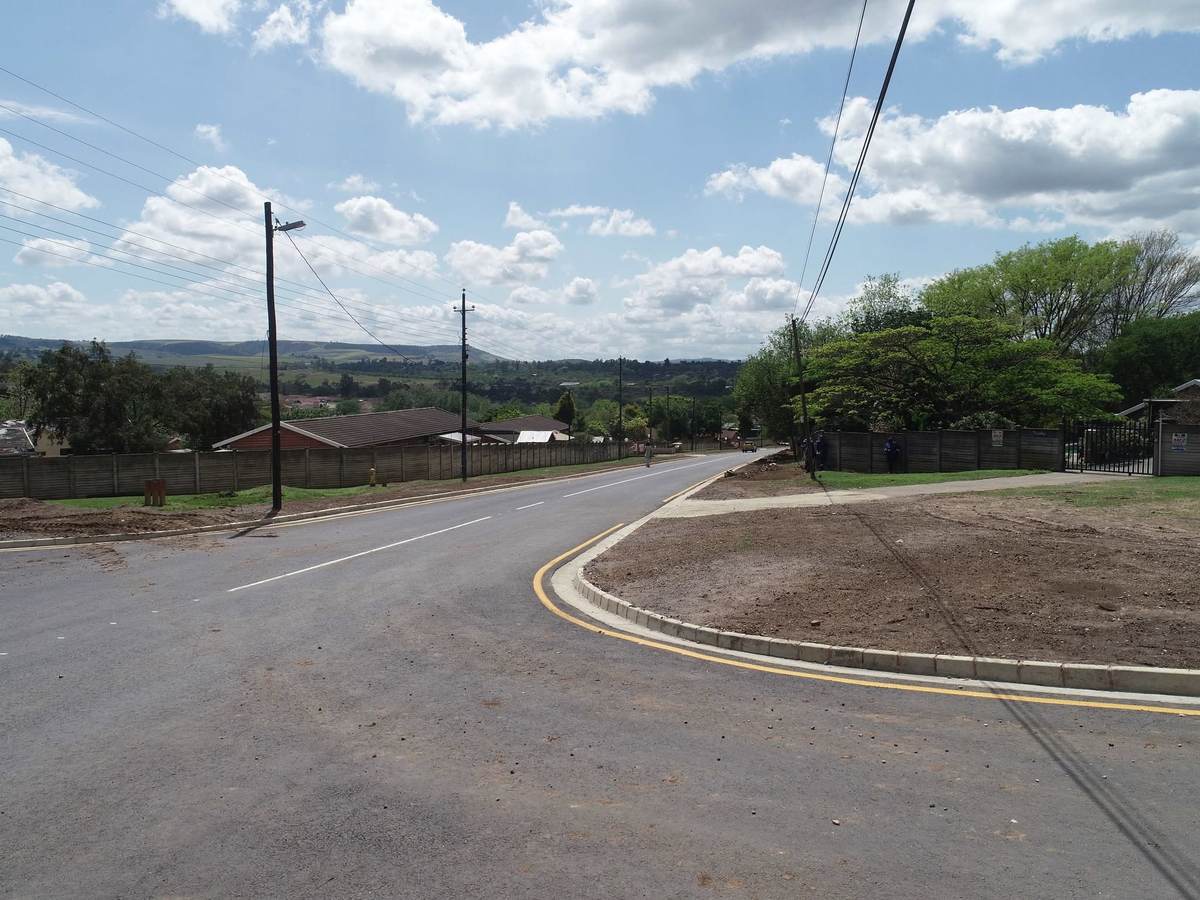 Curved paved road under open sky